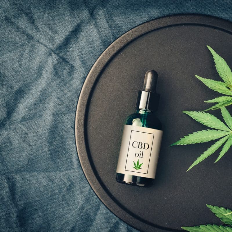 Medical Marijuana Cannabis Products CBD Oil And Hemp Leaves On Dark Background
